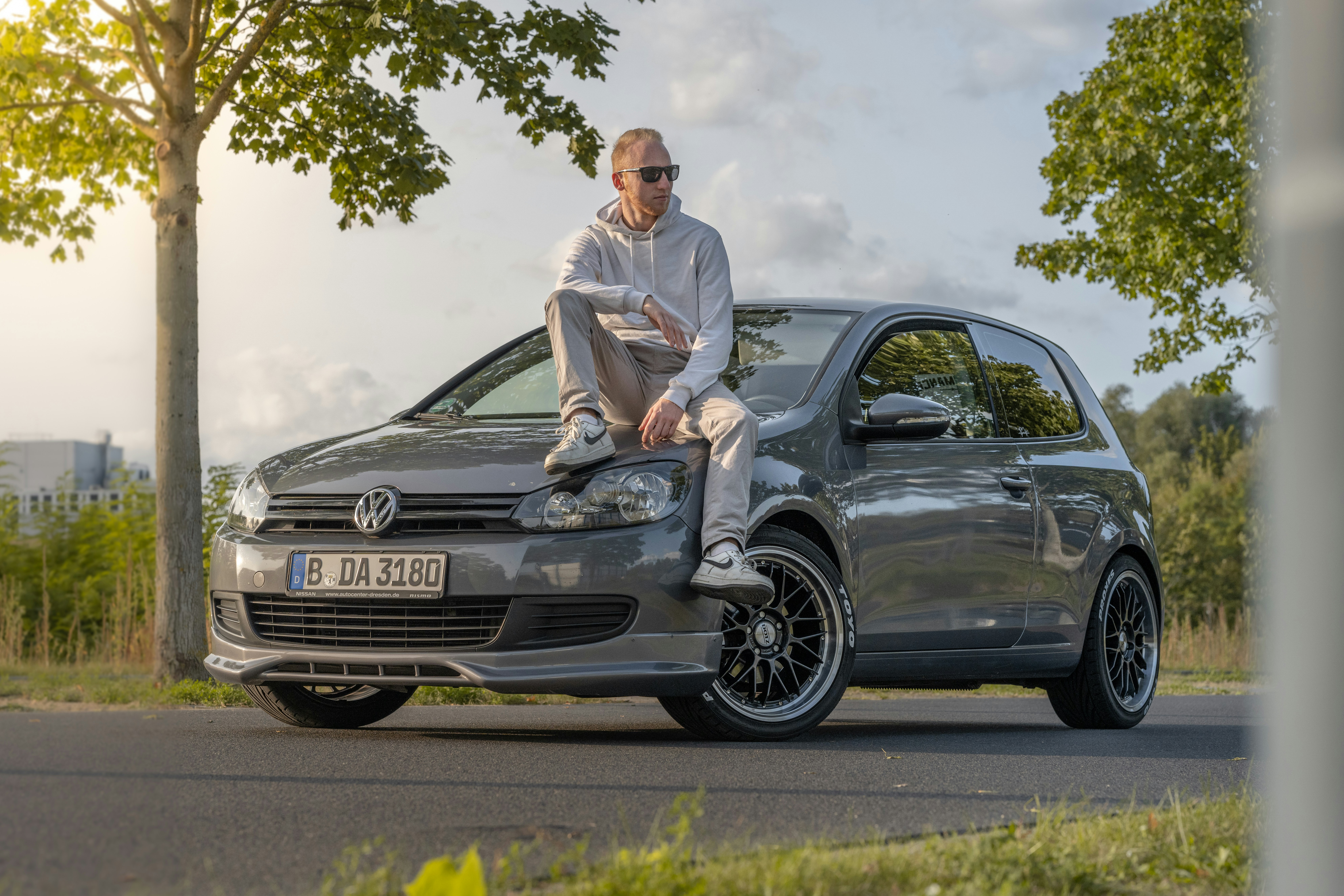 a man sitting on the hood of a car