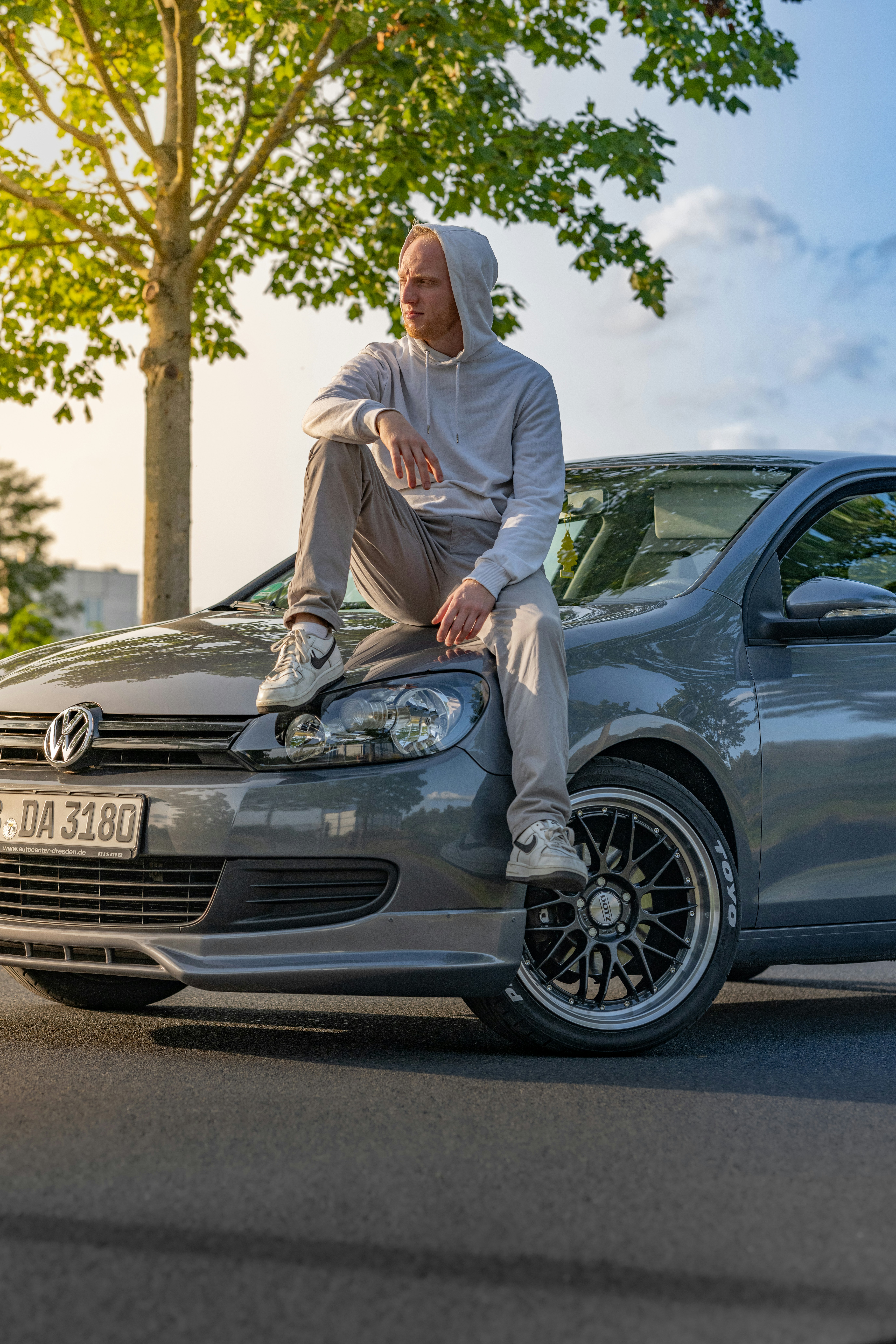 a man sitting on the hood of a car
