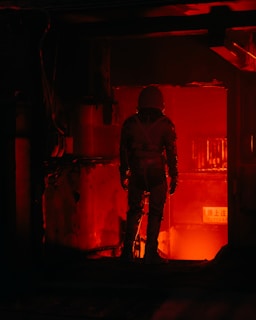 a man standing in a room with a red light
