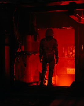 a man standing in a room with a red light