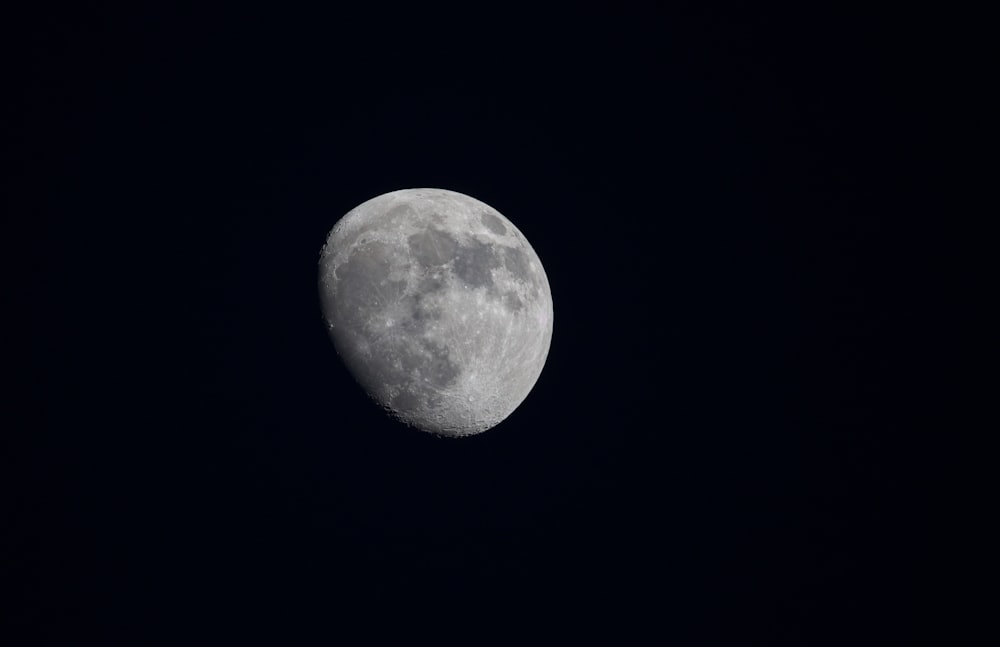 a full moon is seen in the dark sky