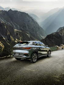 A sleek SUV parked beside a crystal-clear lake in Skardu at sunset.