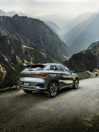 Side profile of a sleek silver Honda SUV against a mountain backdrop.