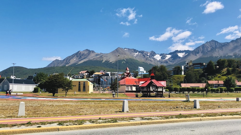a scenic view of a town with mountains in the background