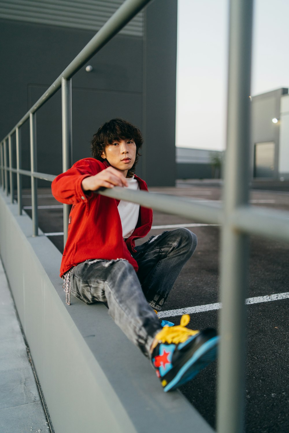 a young man sitting on a ledge with his skateboard