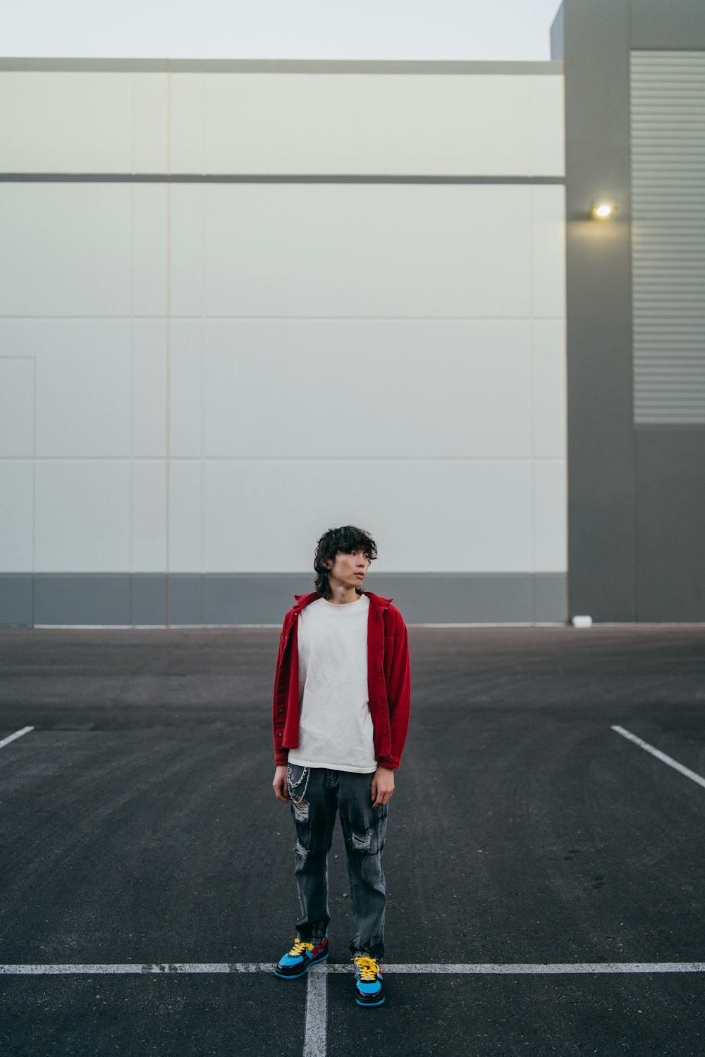 a young man standing in a parking lot