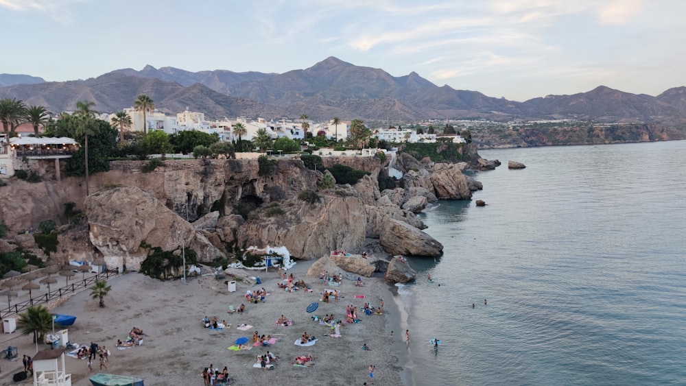 a group of people on a beach next to the ocean