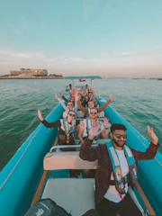 A happy group of colleagues enjoying a sunset boat ride together.