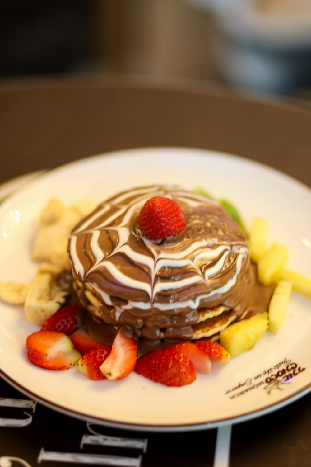 une assiette blanche garnie d’un gâteau au chocolat recouvert de fruits