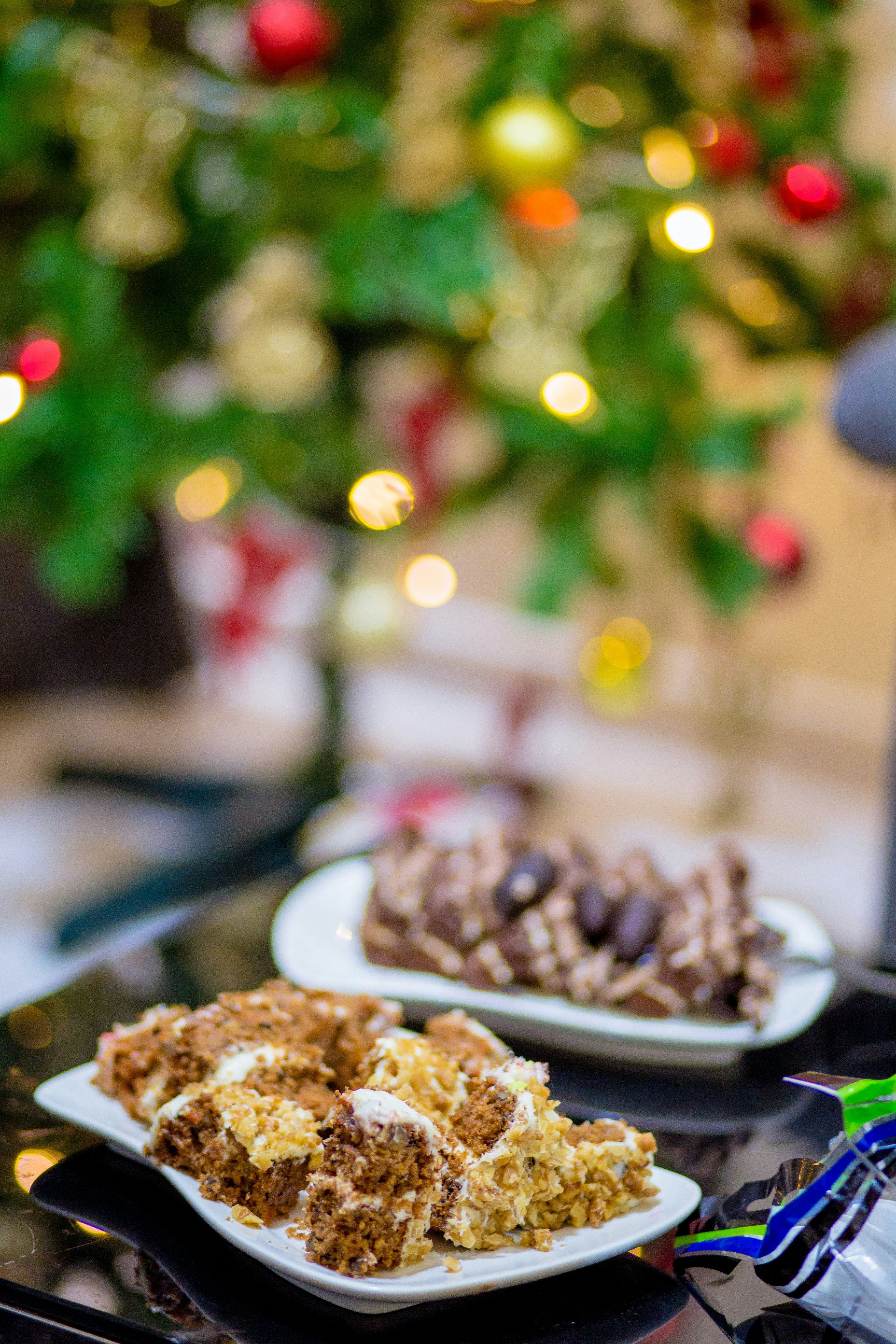 a table topped with plates of food next to a christmas tree