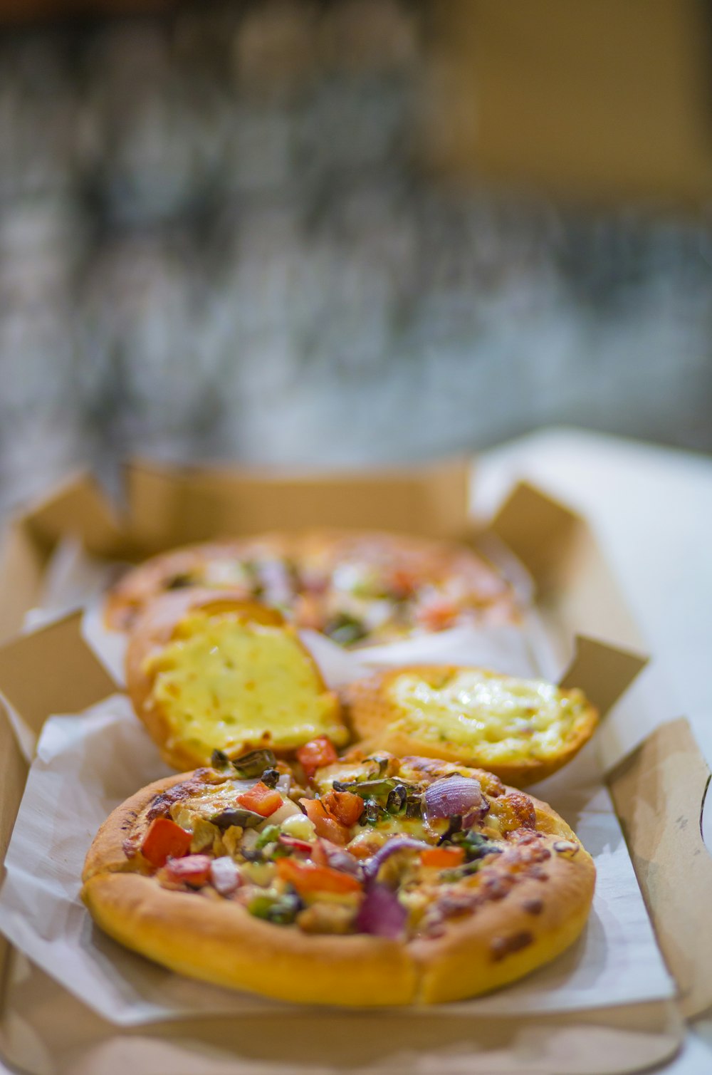 three pizzas sitting in a box on a table