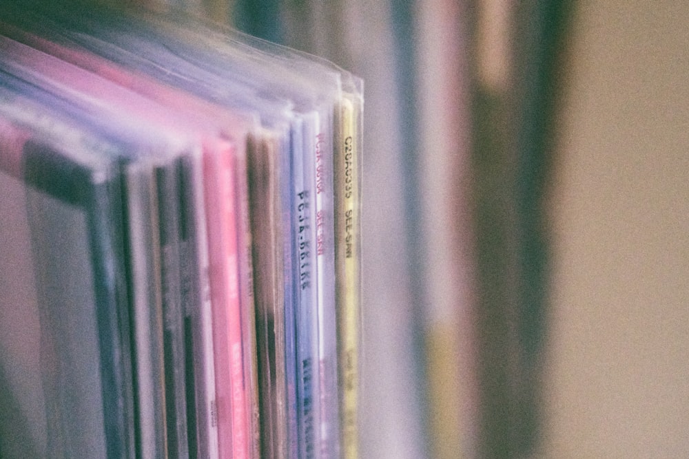 a stack of cds sitting on top of a shelf