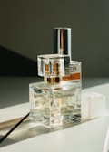 Top view of assorted perfume bottles with reflective surfaces.
