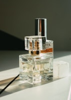 An artistic arrangement of luce fragrance bottles against a sunset backdrop.