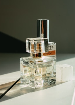 Minimalist perfume bottles arranged on a smooth marble surface with warm light.