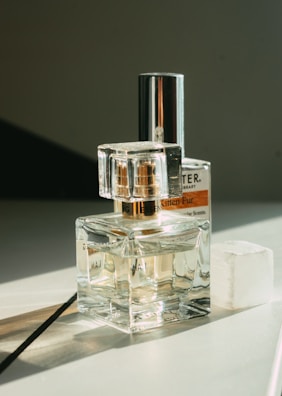 Top view of assorted perfume bottles with reflective surfaces.