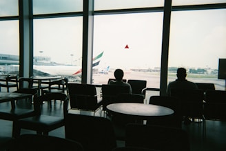 a couple of people sitting in chairs in front of a window