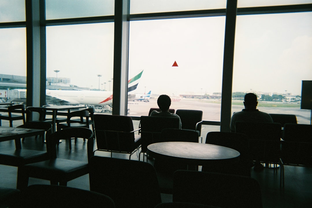 a couple of people sitting in chairs in front of a window,