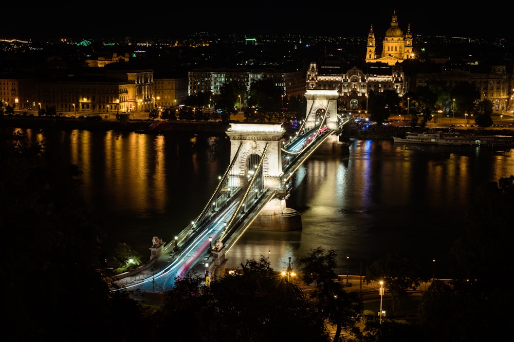 a night time view of a bridge over a body of water