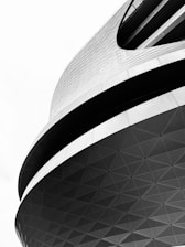 Dynamic architectural structure featuring curved lines and a geometric pattern. The building displays an interplay of light and shadow, emphasizing its modern design.