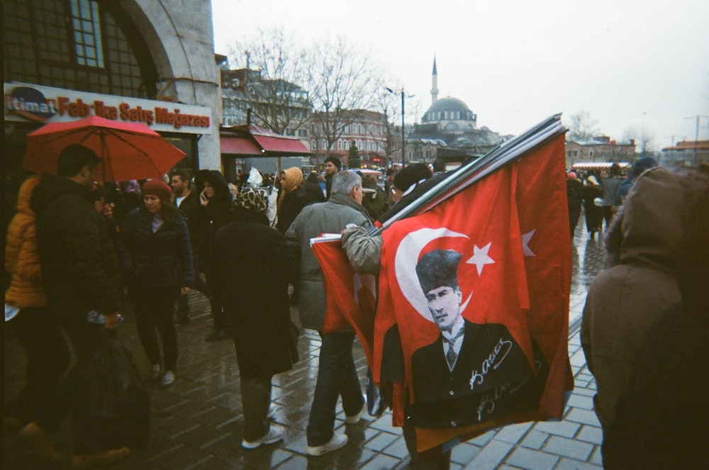 a group of people walking down a street holding flags