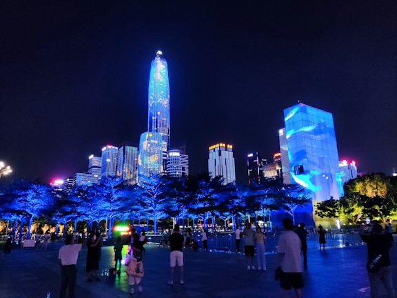 Night cityscape illuminated with vibrant blue and green lights representing technology and finance.