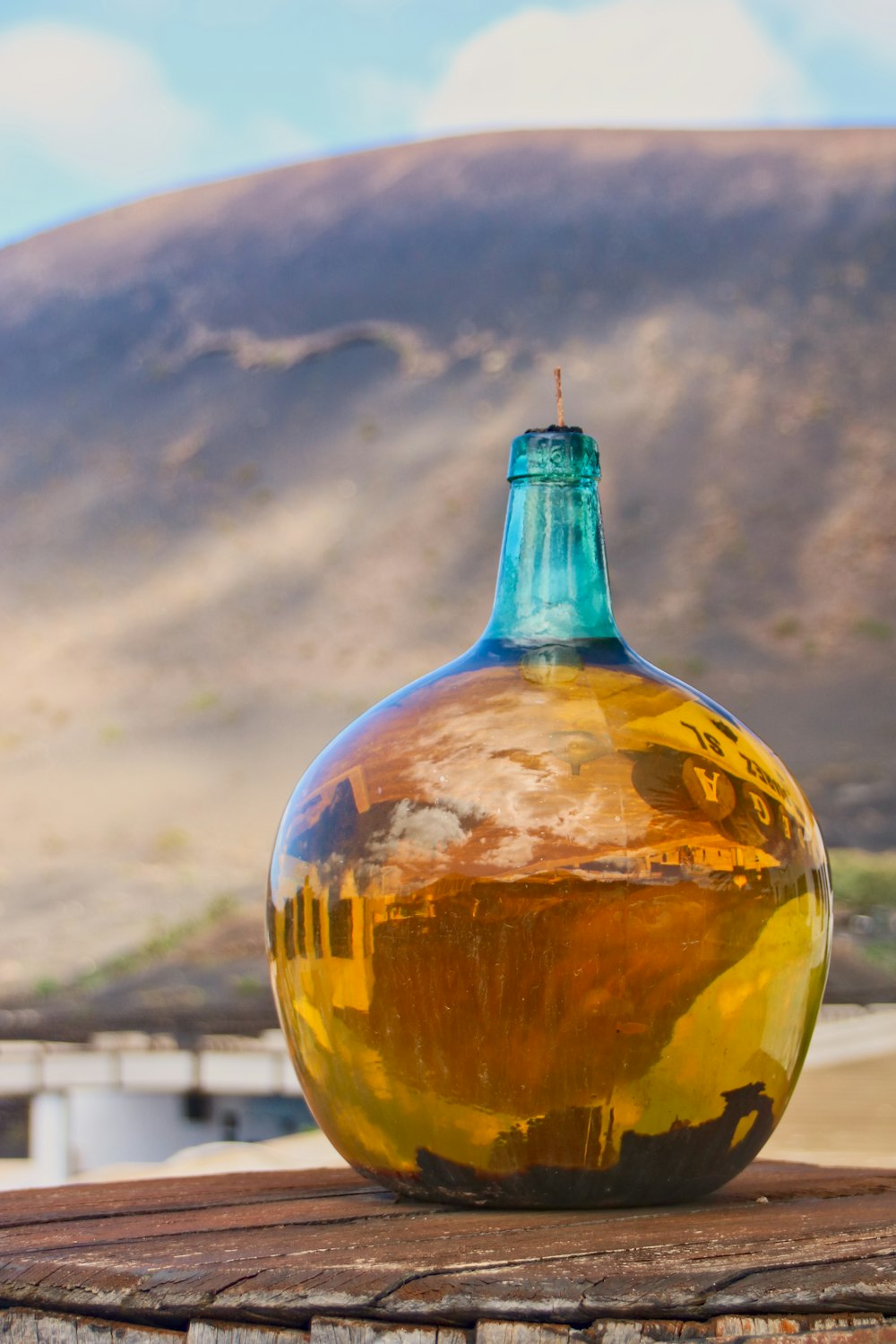 a glass bottle sitting on top of a wooden table