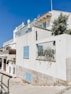a white building with blue shutters and a balcony