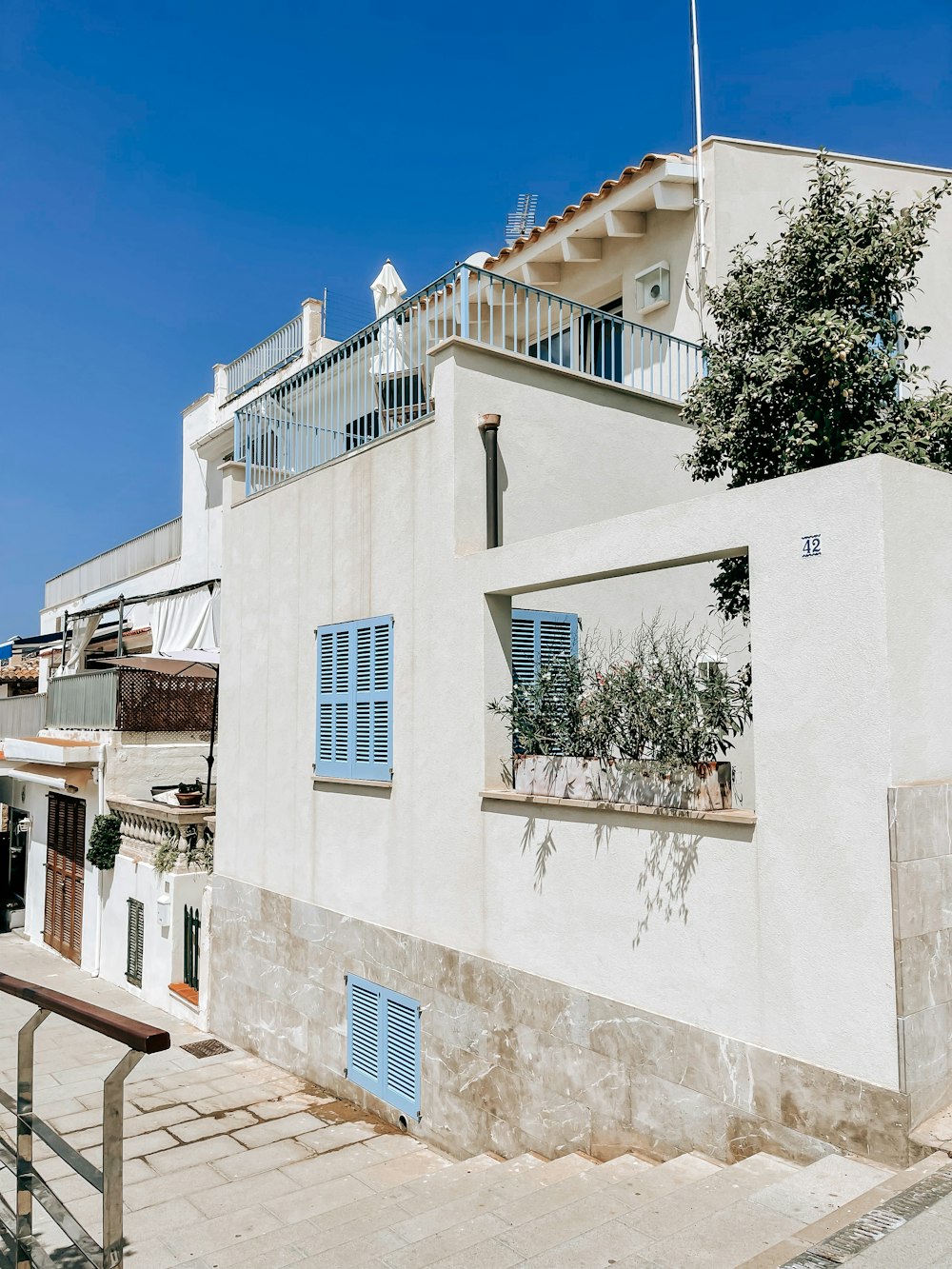 a white building with blue shutters and a balcony