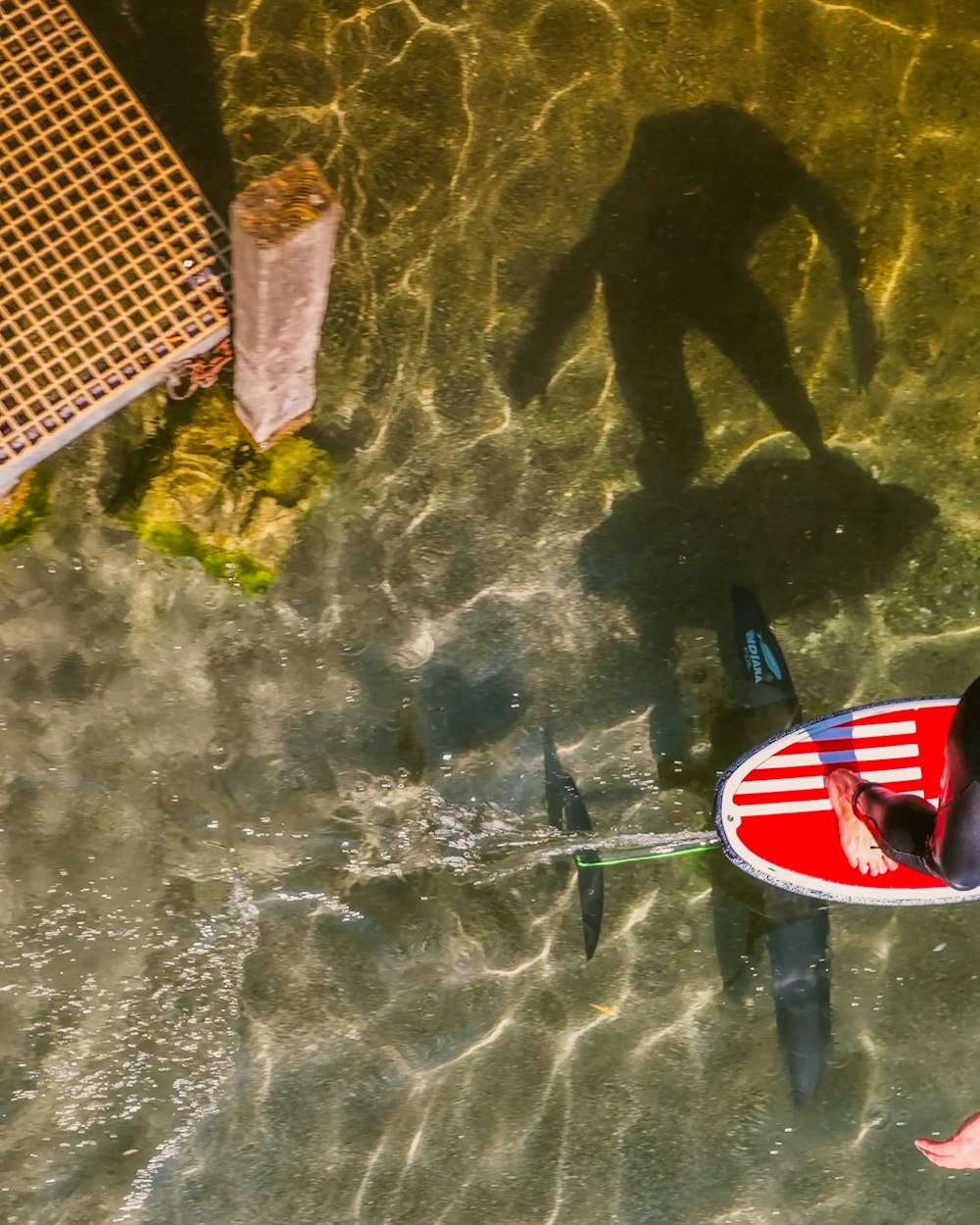 a man riding a red surfboard on top of a body of water