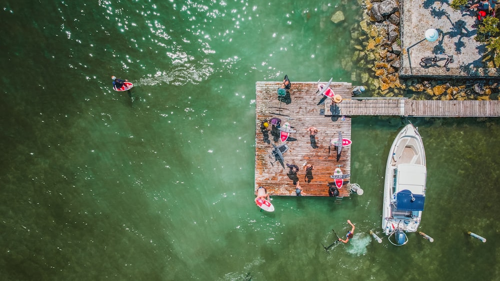 a group of people standing on a dock next to a boat