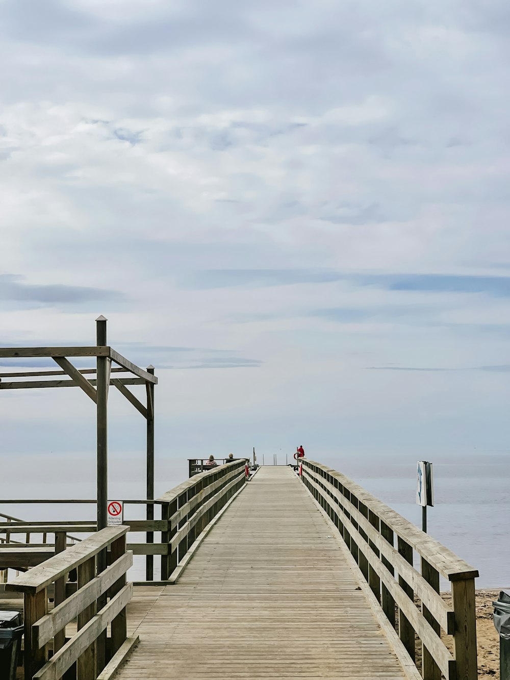 a long wooden pier extending into the ocean