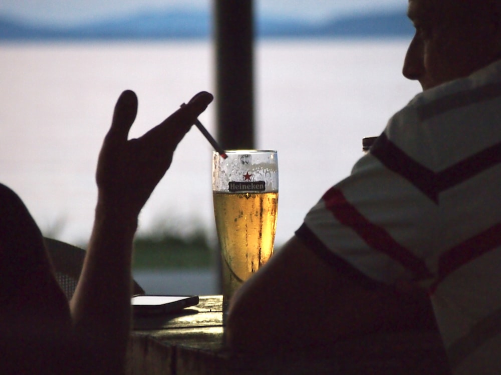 a man sitting at a table with a glass of beer