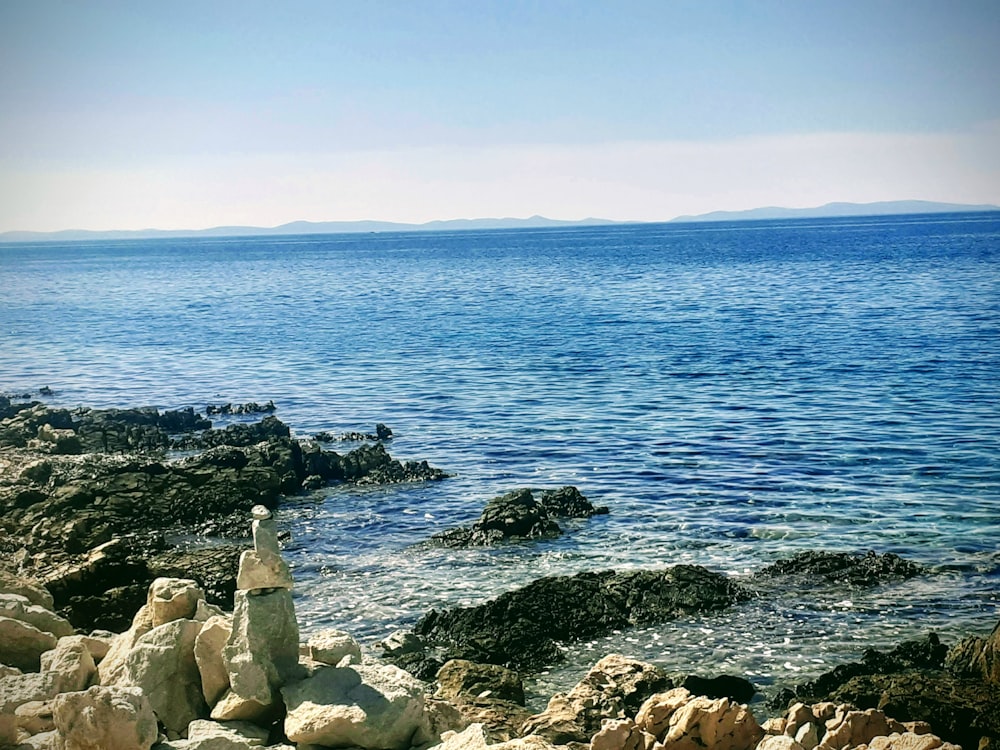 a view of a body of water from a rocky shore