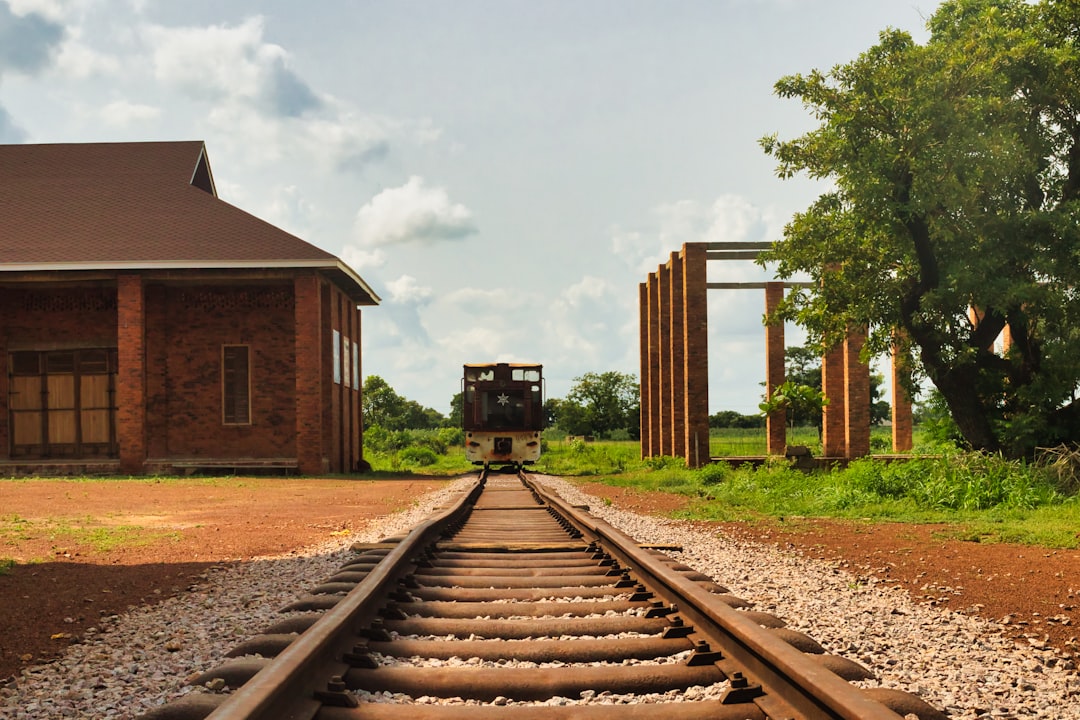 a train traveling down train tracks next to a building,