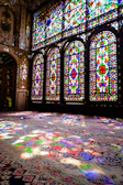 Wide shot of a bright room illuminated by large stained glass panels.