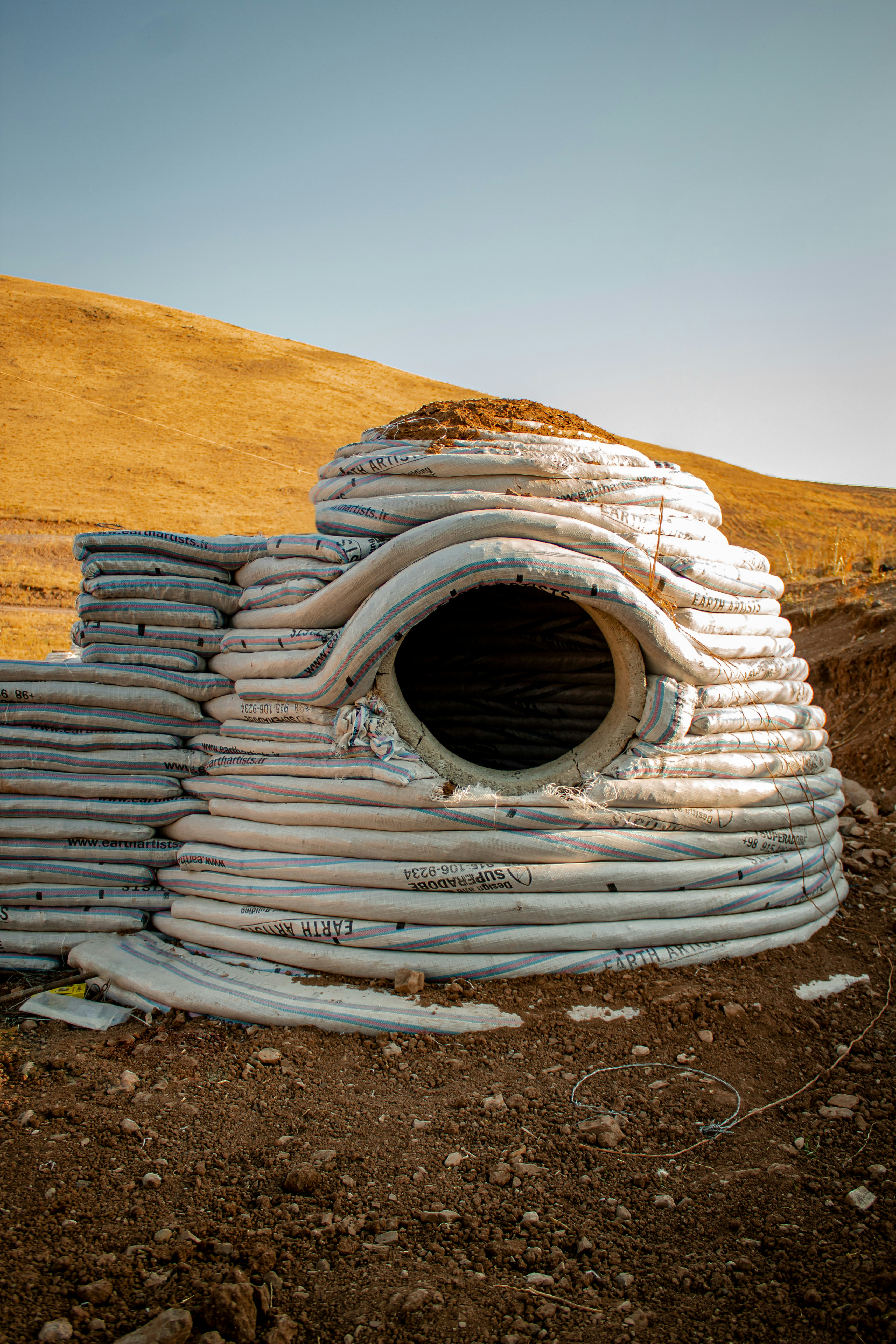 A pile of pipes sitting on top of a dirt field photo – Free Qazvin ...