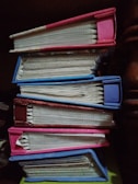 A stack of deluxfully empowered journals and guides arranged on a wooden table.