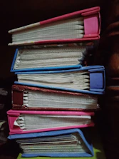 A stack of academic journals with saffron and blue covers on a wooden desk.