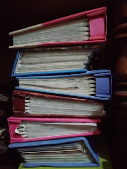 Stack of academic books and journals with a purple and blue color scheme.