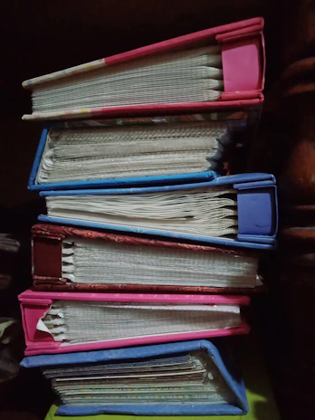 A stack of colorful, girly books with floral covers and soft pink backgrounds.