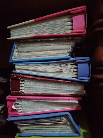 Stacks of educational books with a journal on top.