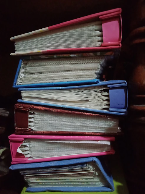 Stack of durable notebooks with various cover designs displayed on a shelf