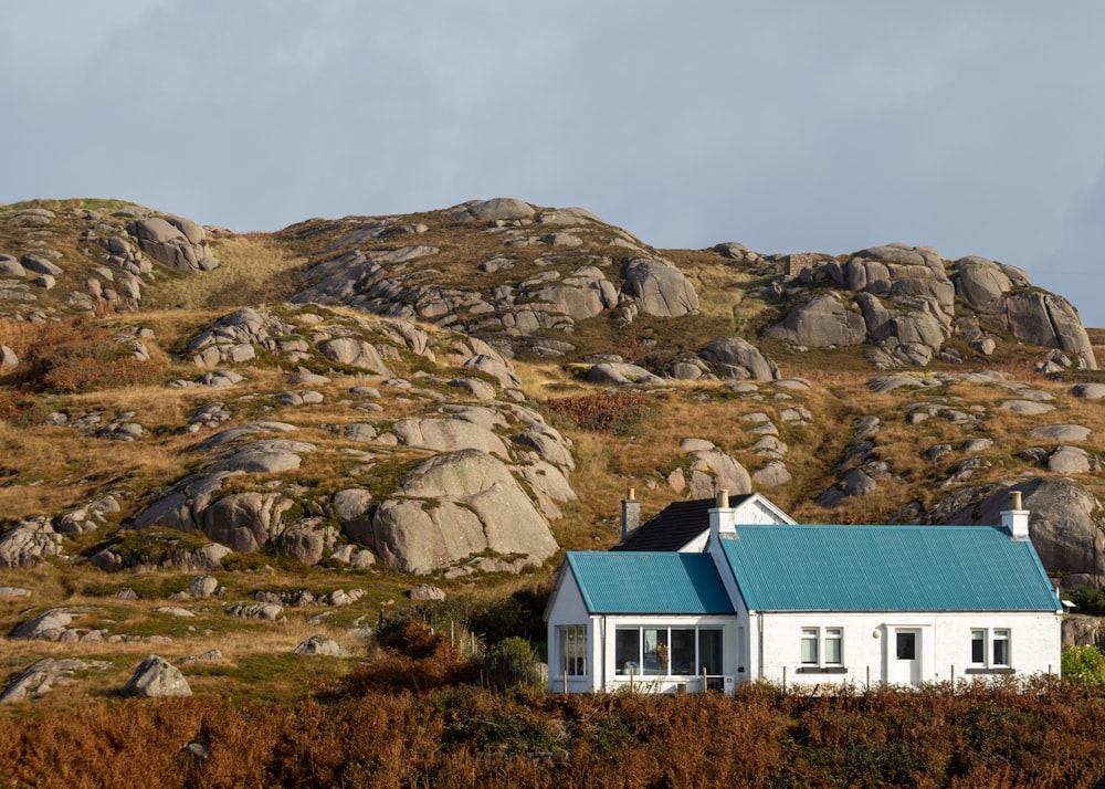 a white house with a blue roof on a hill