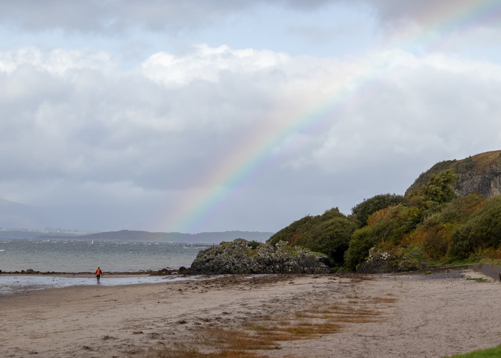 a rainbow in the sky over a beach