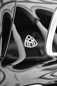 Close-up of a golden emblem on a luxury car door handle reflecting the Panama skyline.