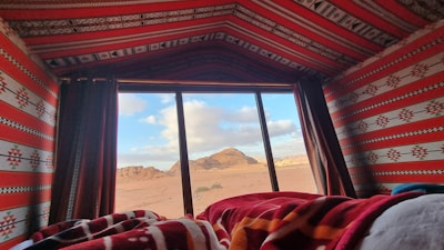 A traditional Berber tent nestled among rocky hills, with cozy blankets and lanterns.