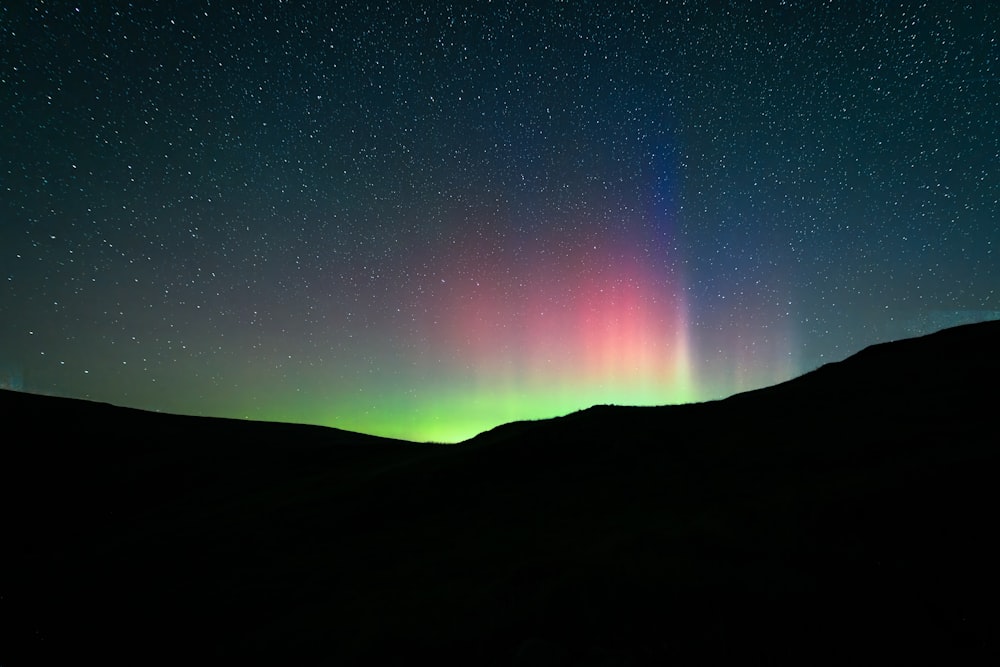 a bright green and red aurora bore in the night sky