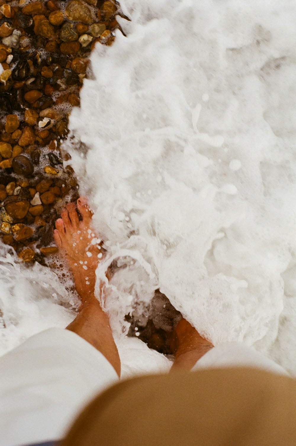 a person standing in the surf with their feet in the water