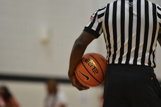 a referee holding a basketball on a court
